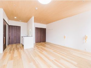 木目調の床と白壁のシンプルな居室内部。採光良好で明るい空間。